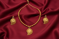 Gold Teardrop Pendant Necklace Set on Red Silk