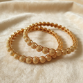 Gold-Tone Textured Ball Dome Bangle Set on Ivory Velvet